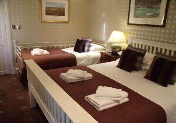 A hotel room with two beds, a radiator, and a lamp on a nightstand. - Sandaig Guest House (Edinburgh)