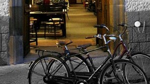 Une porte d’entrée donnant sur un espace intérieur chaleureux et bien éclairé, avec un coin repas et des vélos garés à l’extérieur.