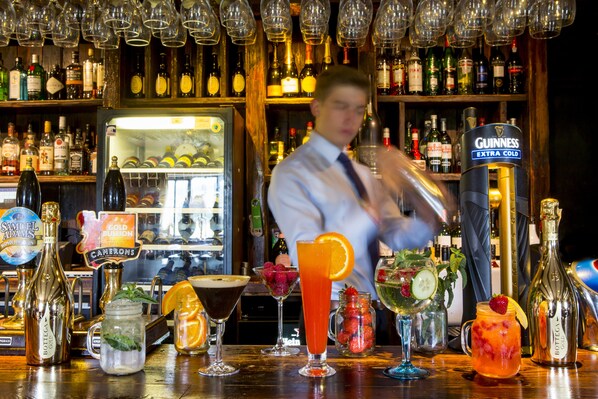 A bar with various bottles and glasses, including a Guinness tap.