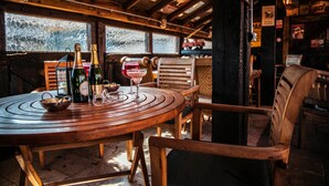 A wooden table with bottles and glasses, a bowl of snacks, and a rustic interior with wooden beams and a view through a window. - South Causey Inn (Stanley)