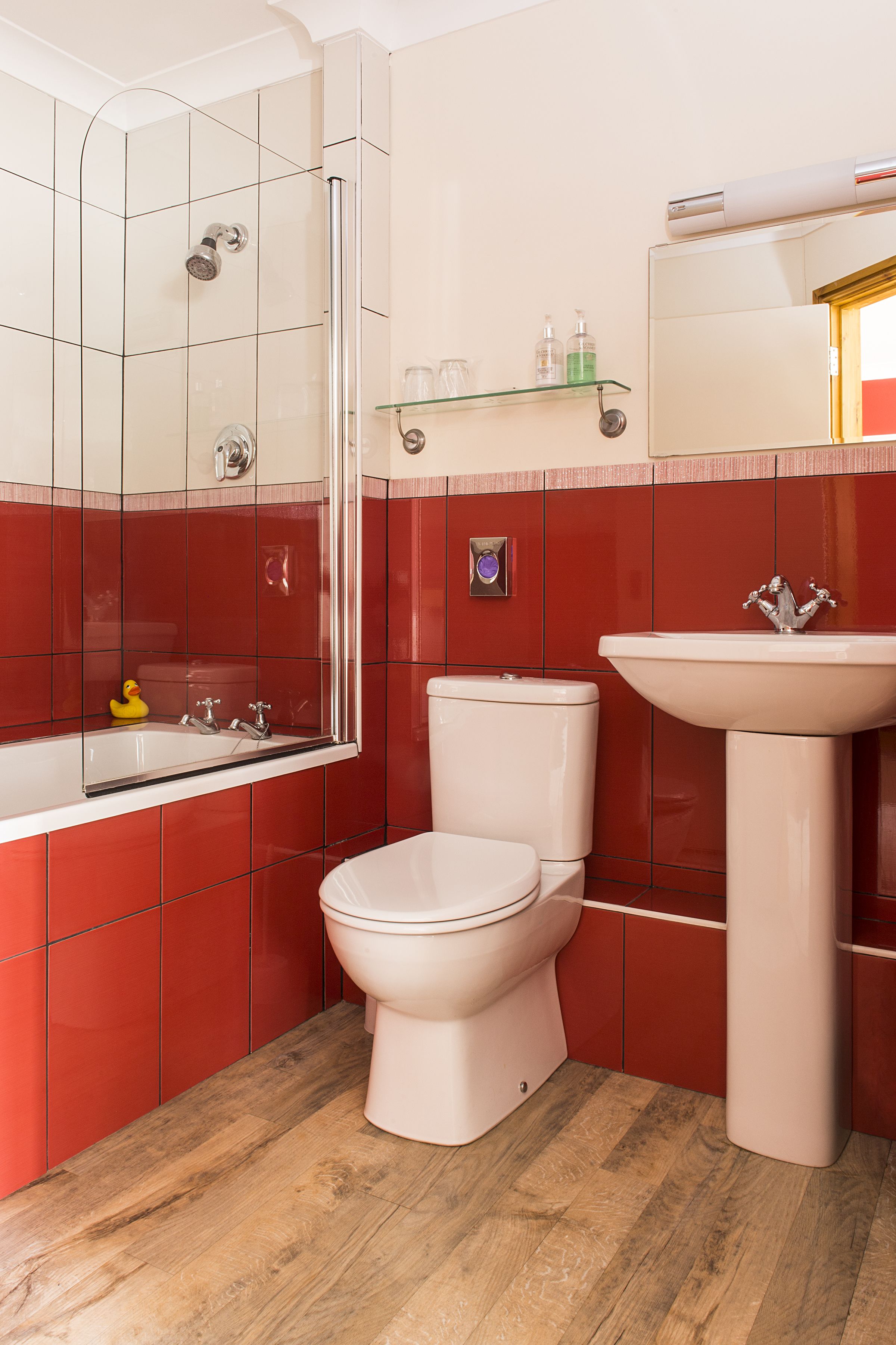 Un baño con inodoro, lavamanos y ducha.