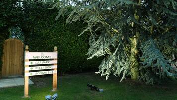 A welcome sign with directions to car park, reception, and rooms 1-8.