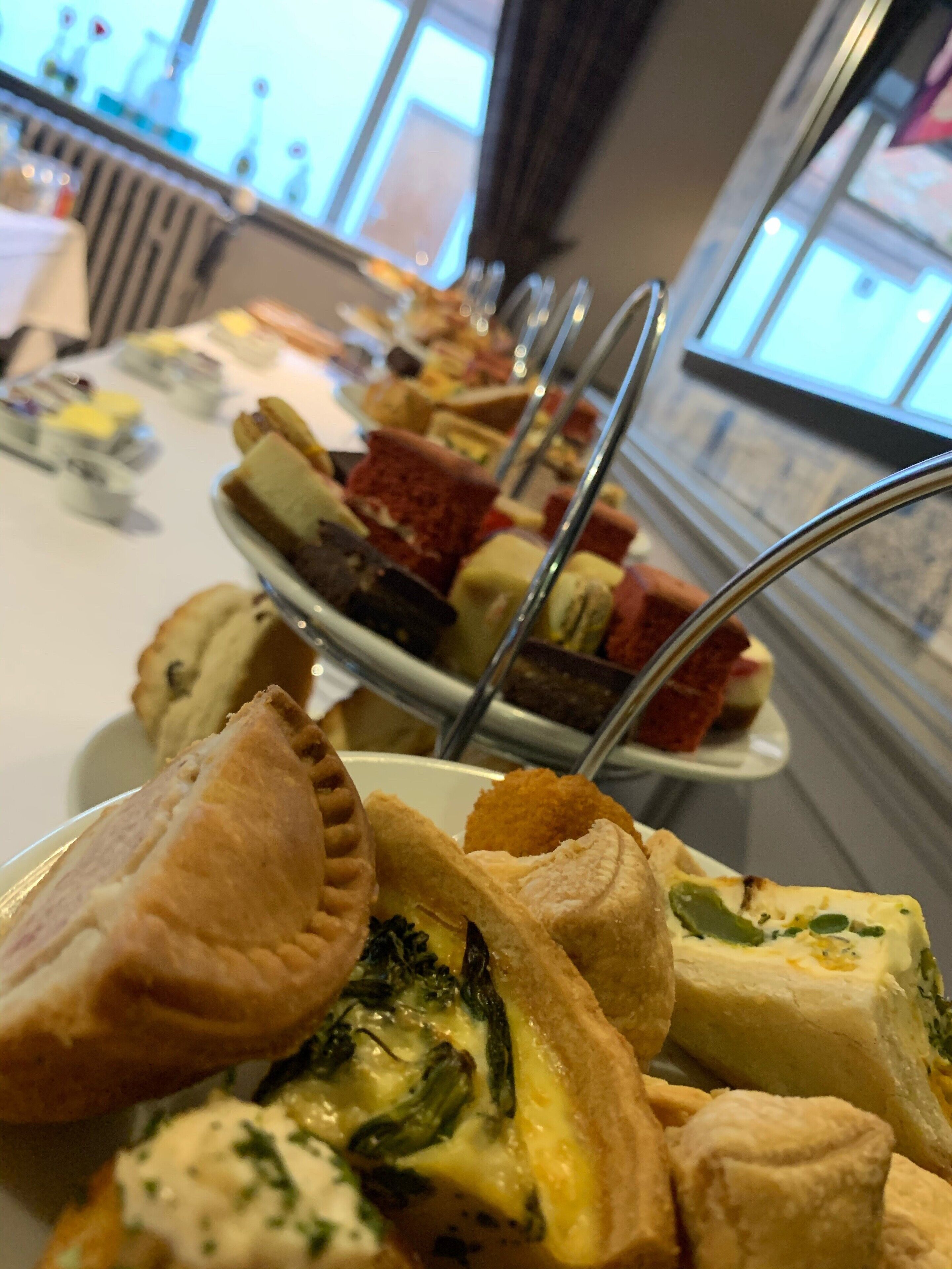 Un buffet proposant divers plats, notamment des tartes et des quiches, disposés sur une table.