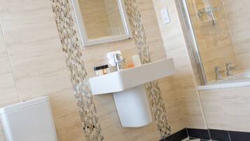 Une salle de bain avec des toilettes, un lavabo et une douche.
