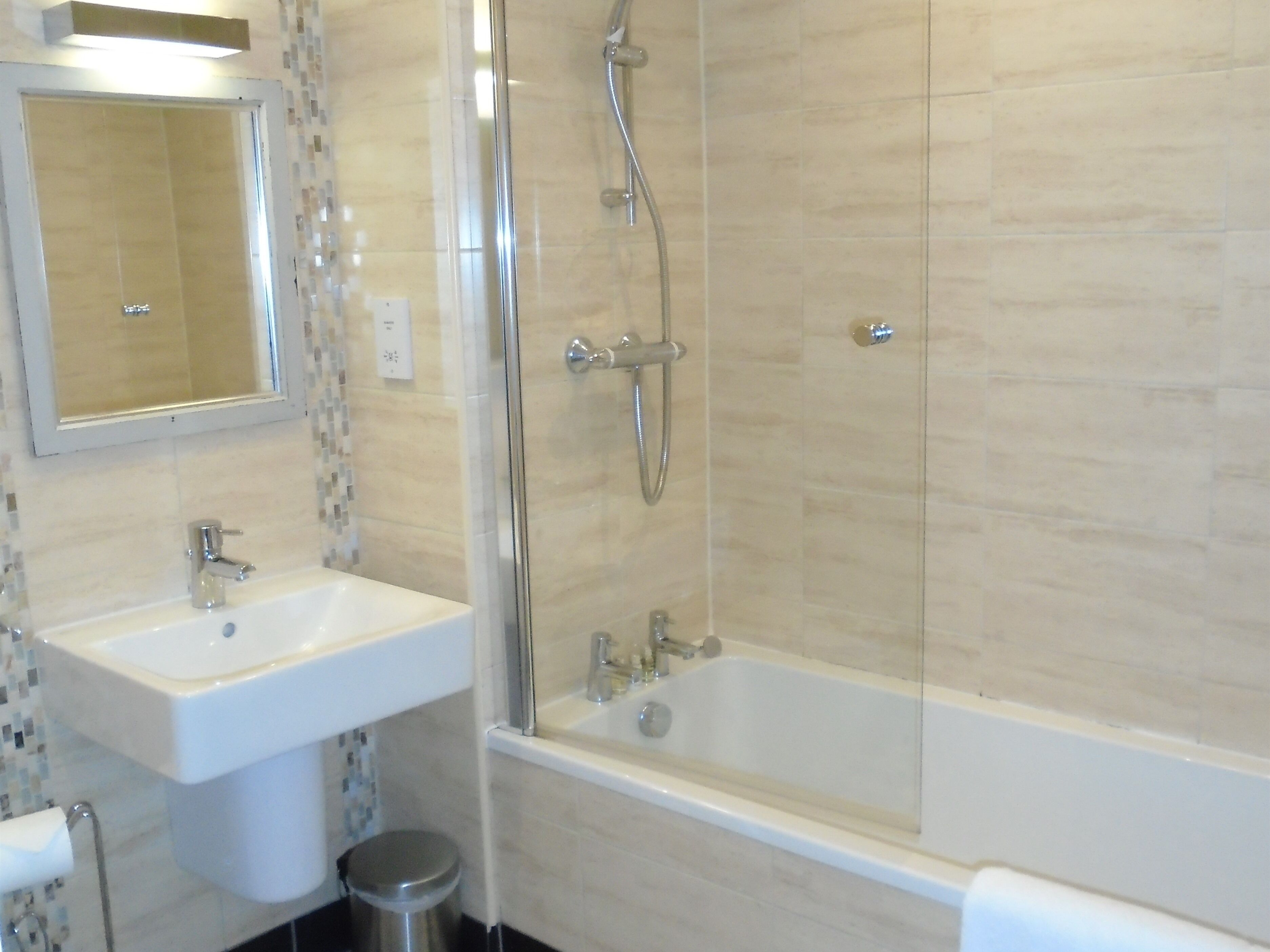 Ein Badezimmer mit Waschbecken, Spiegel und Badewanne.
