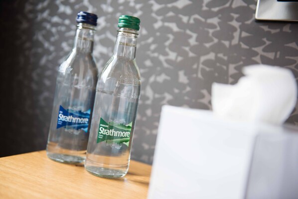 Two empty Strathmore sparkling water bottles on a wooden table. - The County Hotel (Hexham)