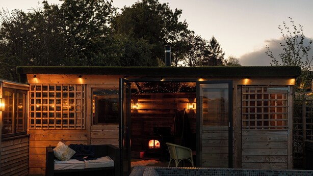 A wooden cabin with a glass door, a small pool, and a fireplace. - The Durham Ox (York)