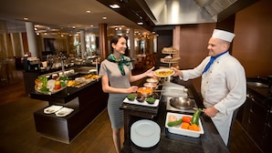 Un montaje tipo bufé en una cocina moderna, con diversas opciones de comida presentadas en bandejas y mesas.