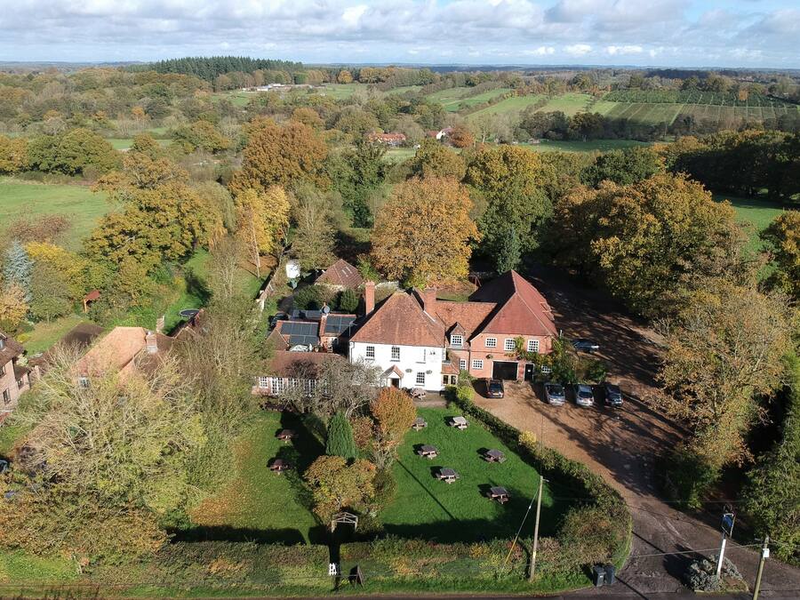 A large estate with multiple buildings, a well-maintained lawn, and a variety of trees.