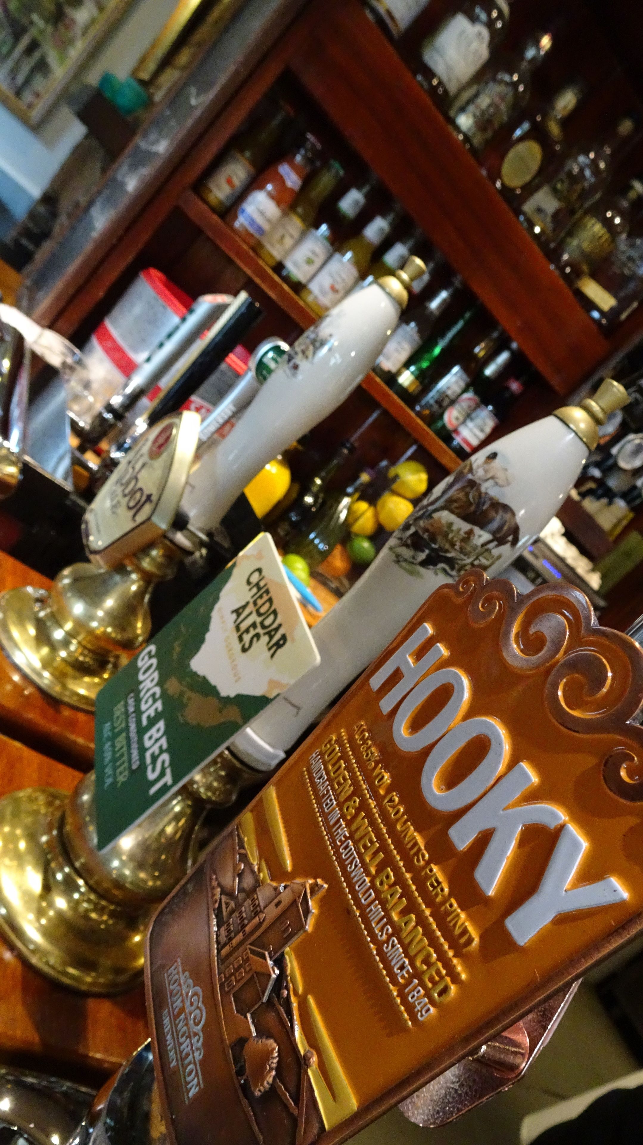 Un bar con varias botellas y un grifo que dice 'Hooky'.