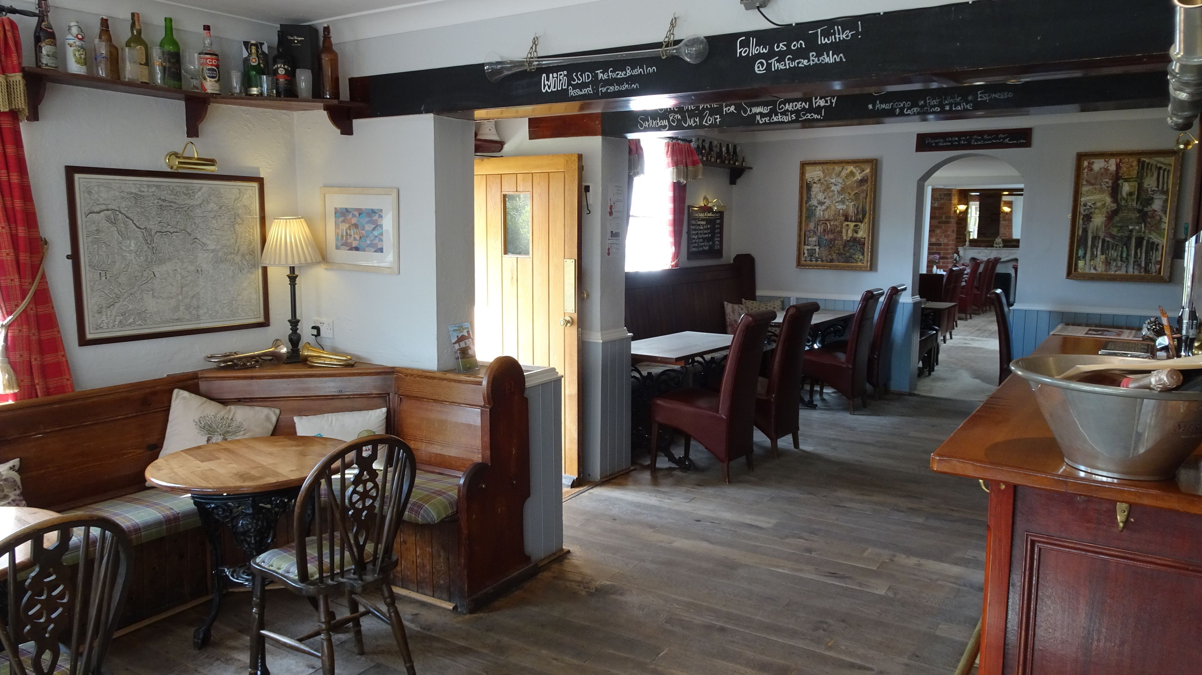 A cozy pub with wooden furniture, a bar area, and a map on the wall.