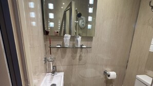 A modern bathroom with a glass shower enclosure, a sink, and a toilet.