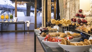 Un bufé con diferentes opciones de comida, incluyendo rosquillas, pasteles y galletas.