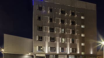 Vista frontal de la propiedad por la tarde o noche