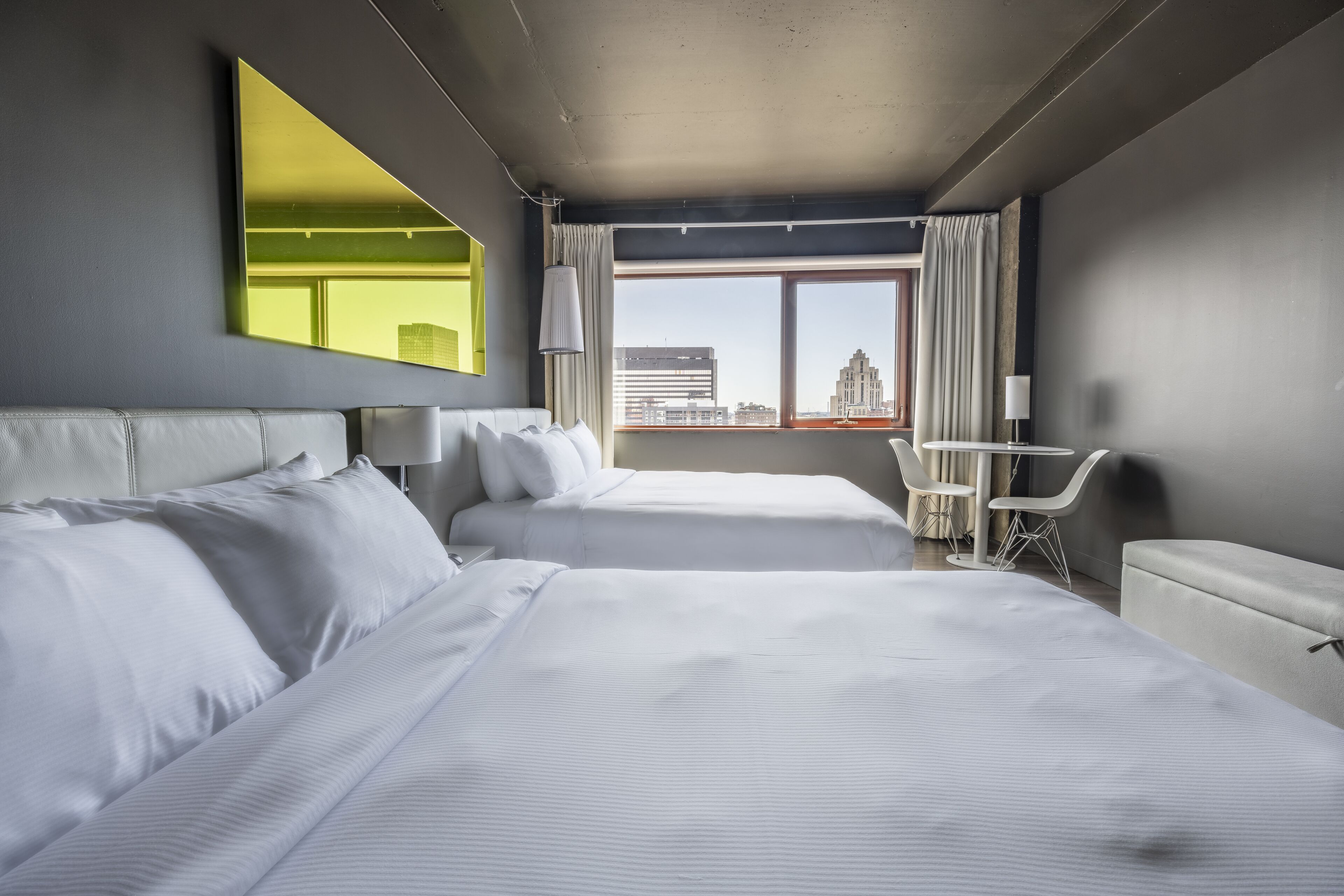 Habitación de hotel con dos camas, un escritorio y una silla.