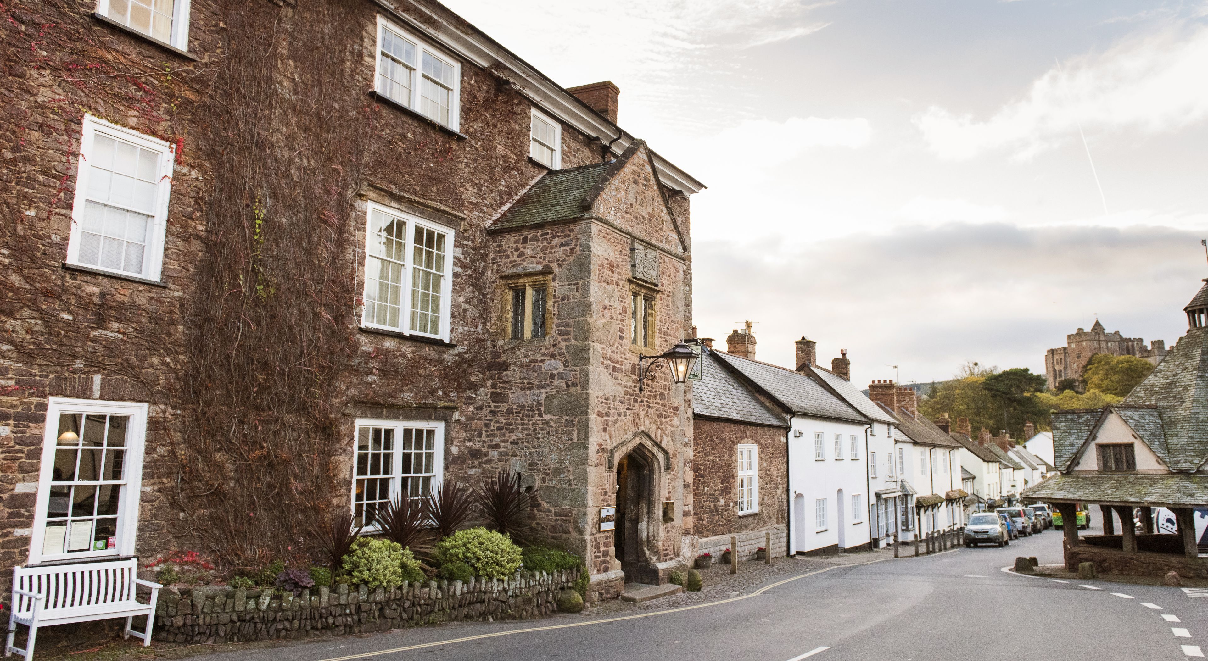 A street lined with traditional stone buildings, some with white windows and others with dark shutters.