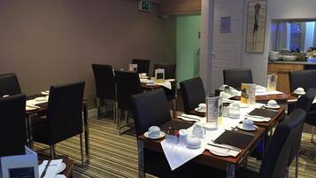 A conference room with tables set for meetings, equipped with nameplates, notepads, and writing instruments.
