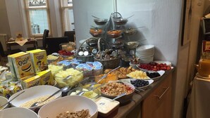Buffet com diversas opções de comida, incluindo cereais, frutas e bebidas.