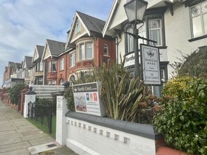 A row of traditional houses with a sign for 'North Crest Guest Accommodation' indicating a hotel. - North Crest (Blackpool)