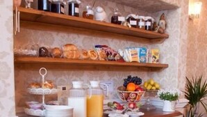 Un bufé de desayuno con diversas opciones de comida y bebidas sobre estantes de madera y una barra.