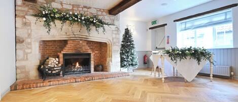 Una habitación con chimenea, un árbol de Navidad y una mesa con mantel blanco.