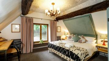 Una camera da letto con un letto grande, un soffitto in legno, un lampadario e vista sull'esterno.
