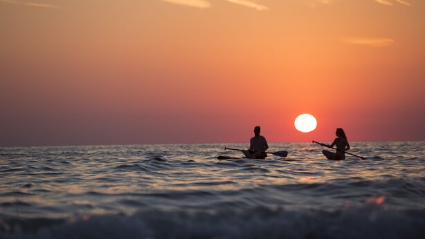 Two people sitting on a boat in the ocean at sunset. - Hyatt Place Sarasota/Bradenton Airport (Sarasota)