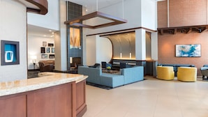 A modern lobby with a reception desk, seating area, and a fireplace. - Hyatt Place Sarasota/Bradenton Airport (Sarasota)