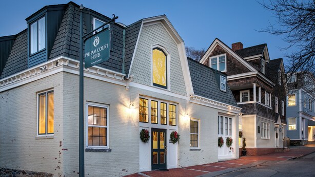 Un hotel tradicional con fachada blanca, techo oscuro y un cartel que indica que es el Pelham Court Hotel.