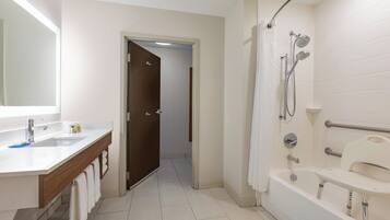 A modern bathroom with a shower, a bathtub, and a vanity with a mirror.