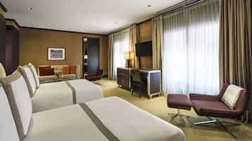 Habitación de hotel con dos camas, un escritorio, una silla y un televisor.