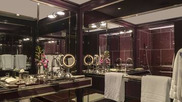 A luxurious bathroom with a large mirror, multiple round mirrors, a vanity with a sink, and a towel rack.