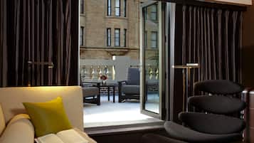 Un salon moderne avec un canapé, un fauteuil de lecture et une table sur laquelle se trouvent un livre et un vase.