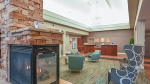 A lobby with a stone fireplace, comfortable seating, a reception desk, and a high ceiling with skylights. - Residence Inn by Marriott Cincinnati North/West Chester (West Chester)