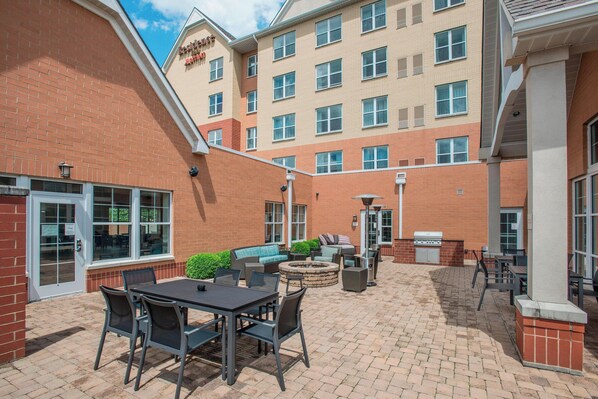 A courtyard with outdoor seating, a fire pit, and a barbecue grill.