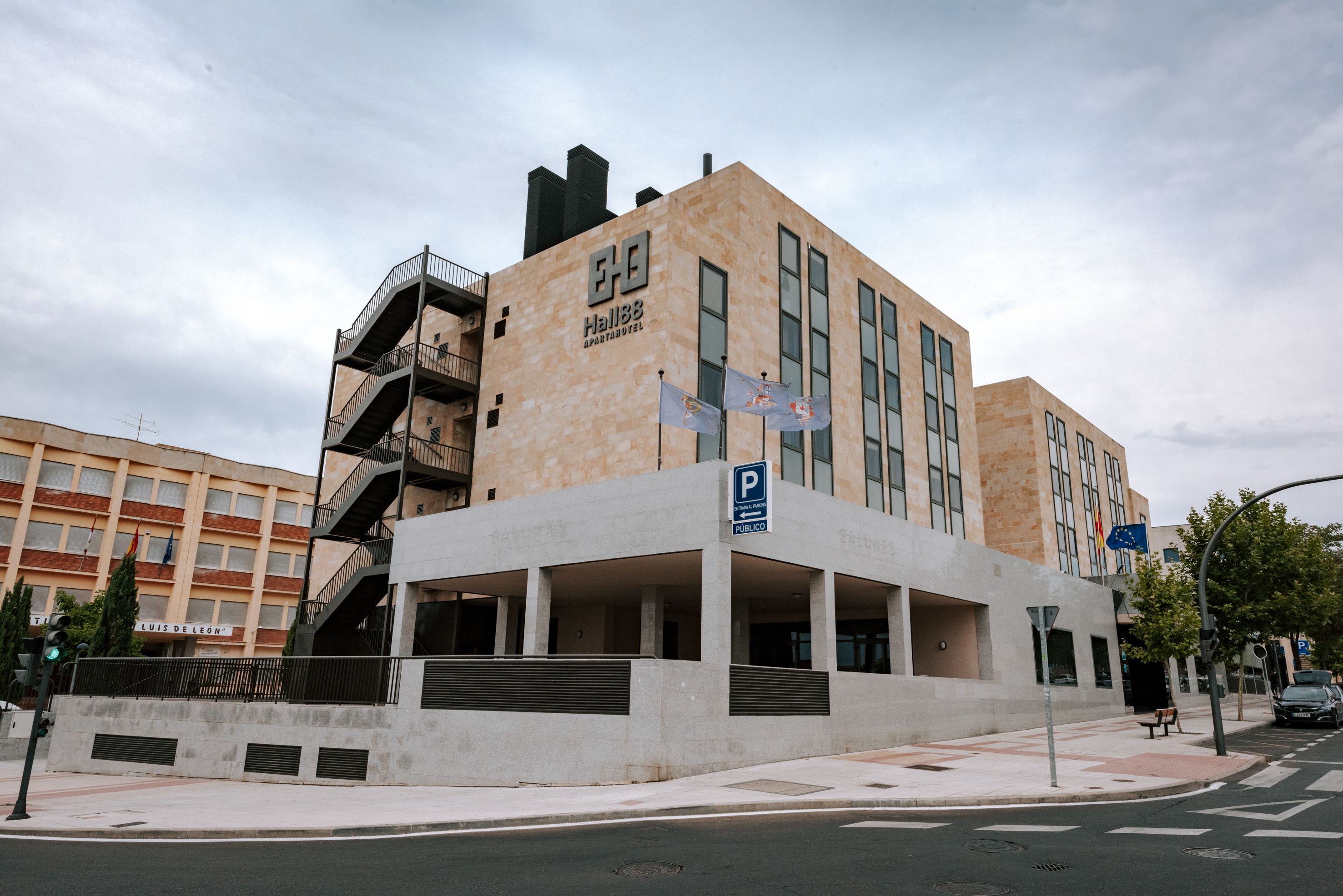Un edificio moderno con un letrero de estacionamiento 'P', varios pisos y una entrada pública.