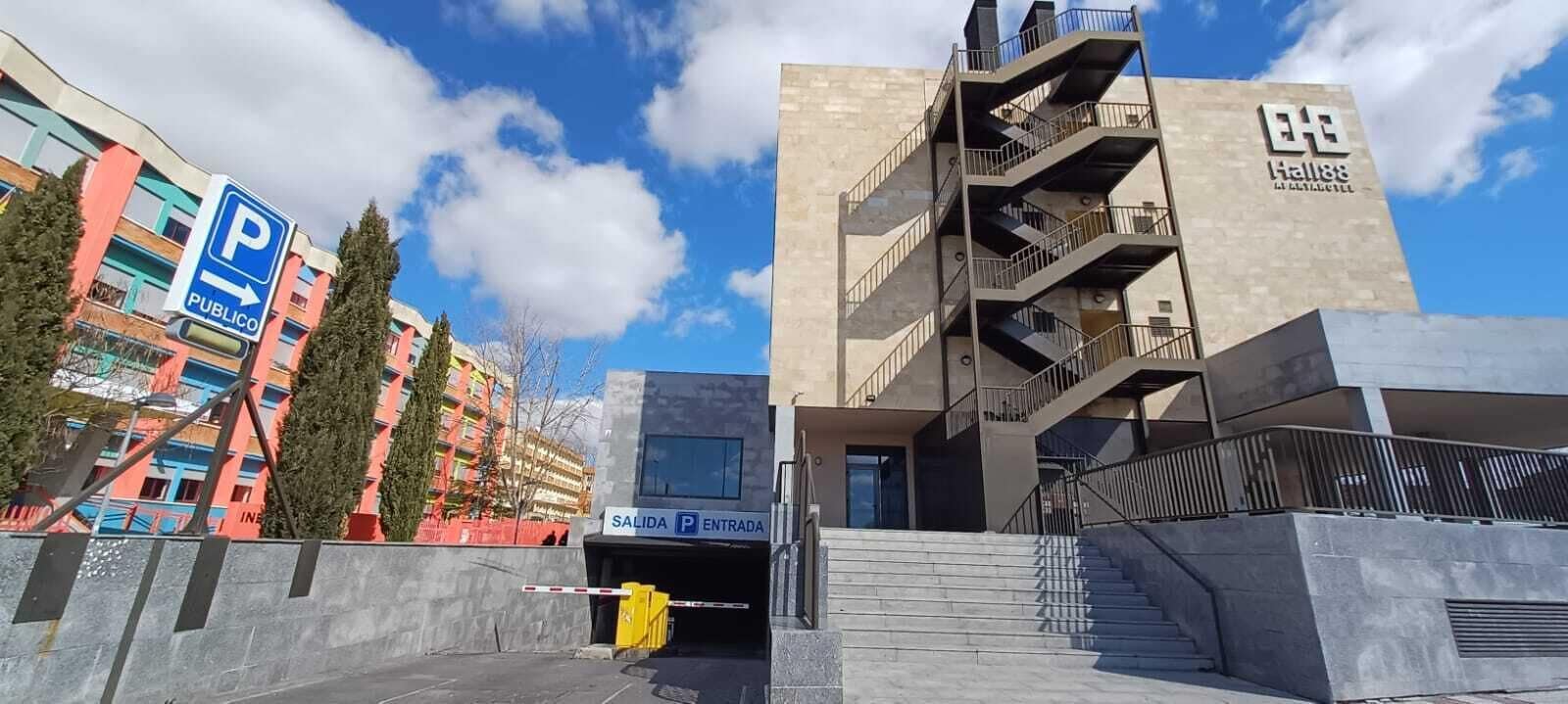 A modern building with a parking entrance labeled "SALIDA P ENTRADA" and a "P PUBLICO" sign indicating public parking.
