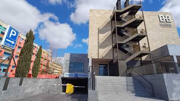A modern building with a parking entrance labeled "SALIDA P ENTRADA" and a "P PUBLICO" sign indicating public parking.