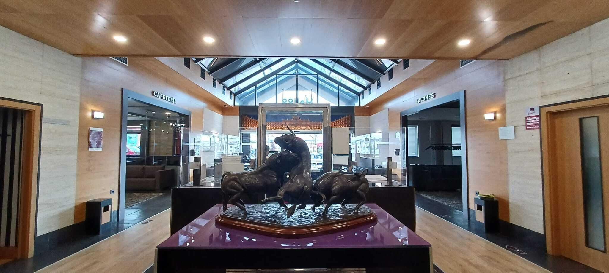 A lobby with a central sculpture of bulls, a cafe, and a salon.