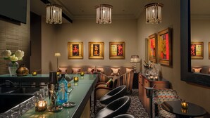 A bar area with a green counter, black chairs, and a patterned floor. - Rocpool Reserve (Inverness)