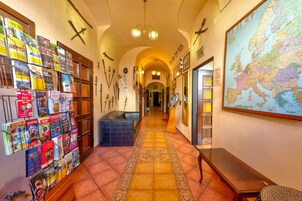 Un pasillo con un mapa, un tablón de anuncios con revistas y un banco.