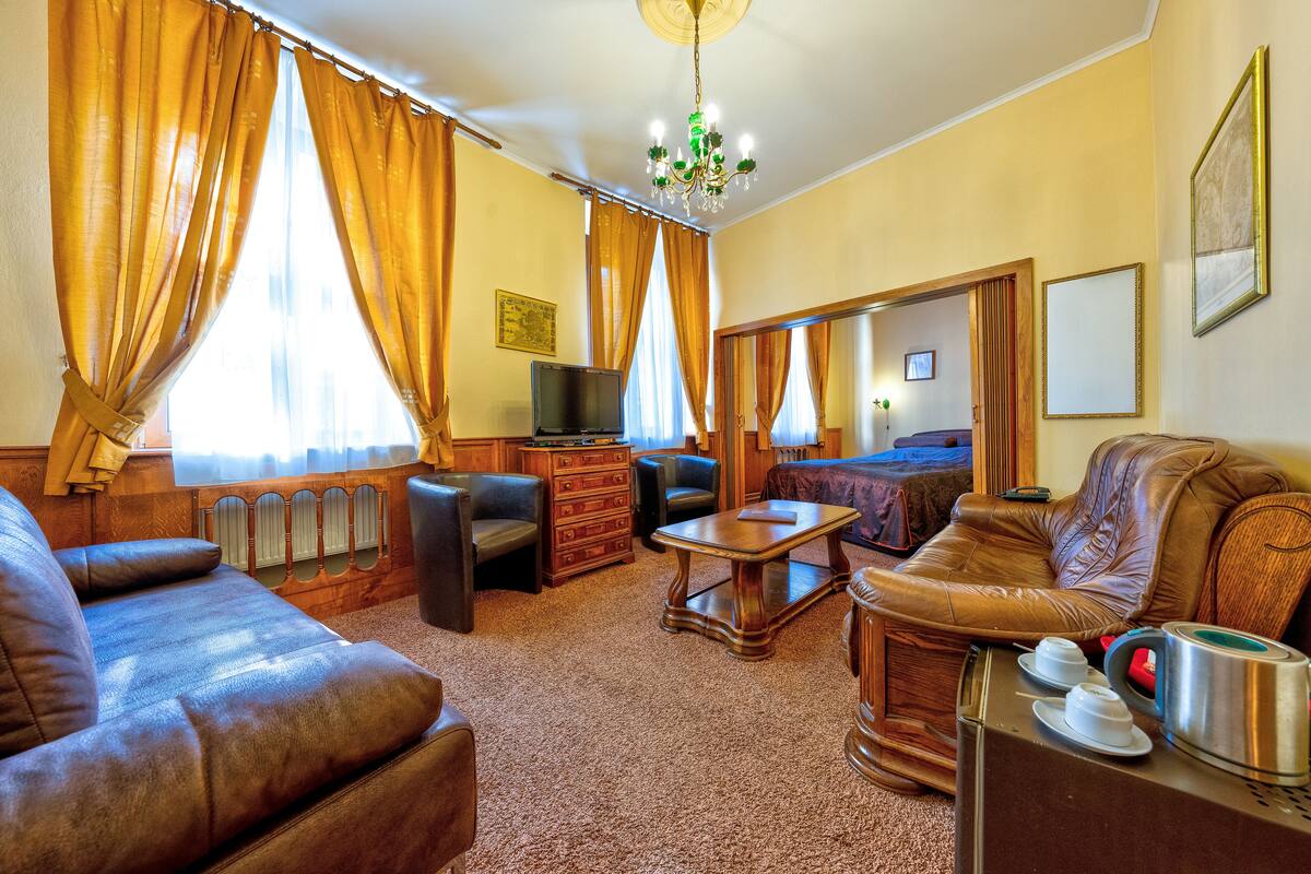 A cozy living room with a brown leather sofa, a wooden coffee table, and a television.