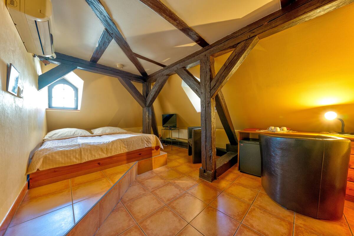 A bedroom with a bed, a desk, and a chair.