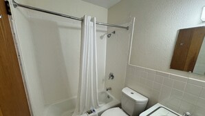 Et badeværelse med badekar, toilet og håndvask.
