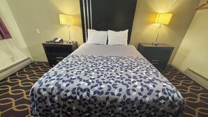 Et hotelværelse med en seng, to sengeborde med lamper, en telefon og et mønstret tæppe.
