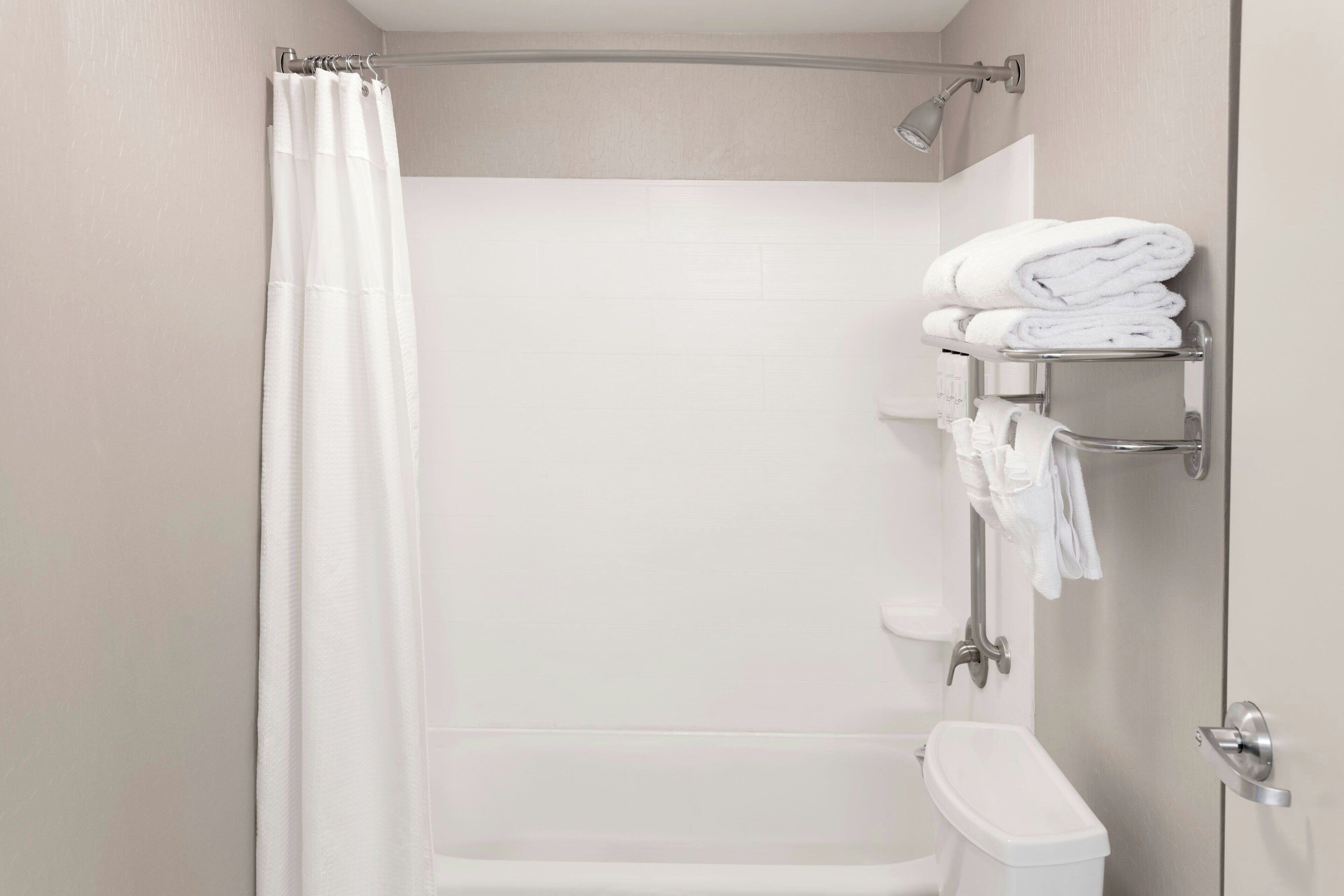 Un bagno moderno con doccia, WC e porta asciugamani.