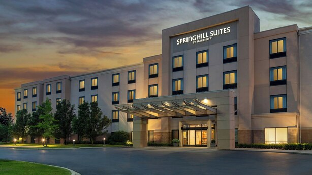 A hotel with a modern facade, multiple floors, and a covered entrance. - SpringHill Suites Detroit Auburn Hills (Lake Orion)
