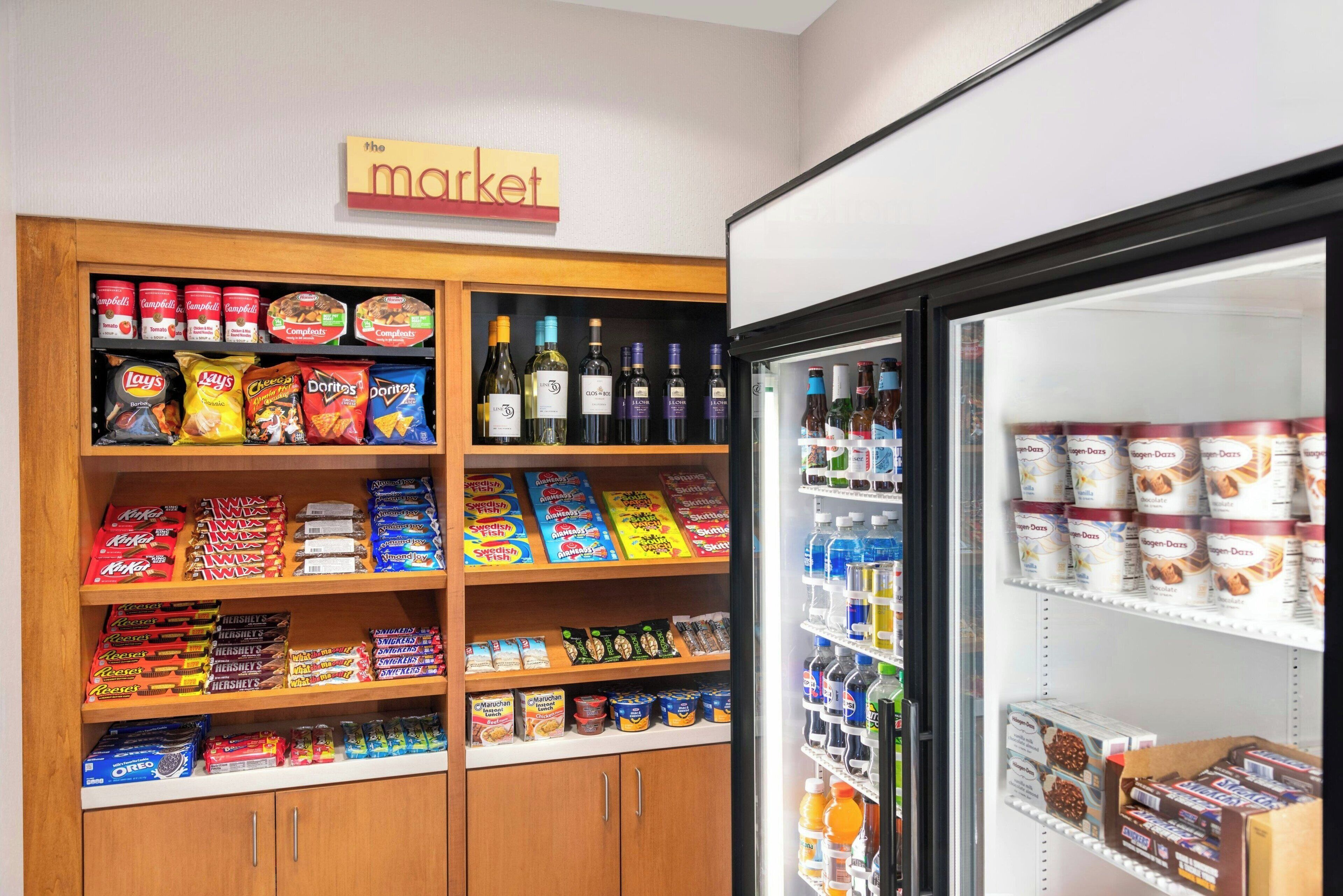 Una exhibición de aperitivos y bebidas en una tienda, con un letrero en la parte superior que dice 'the market'.