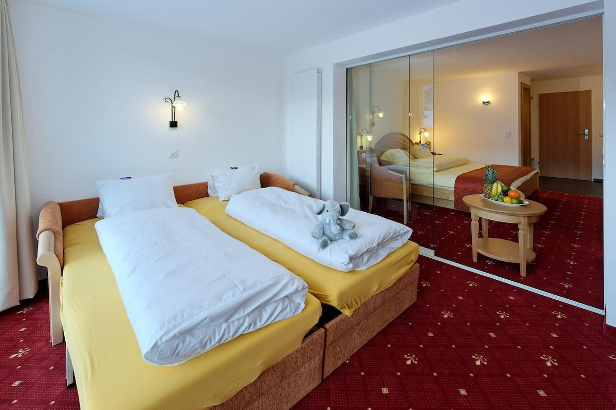 Suite familiar, vista a la montaña | 1 habitación, minibar, caja de seguridad en la habitación y escritorio