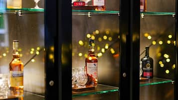 Una vitrina con varias botellas y vasos, probablemente en un bar o hotel.
